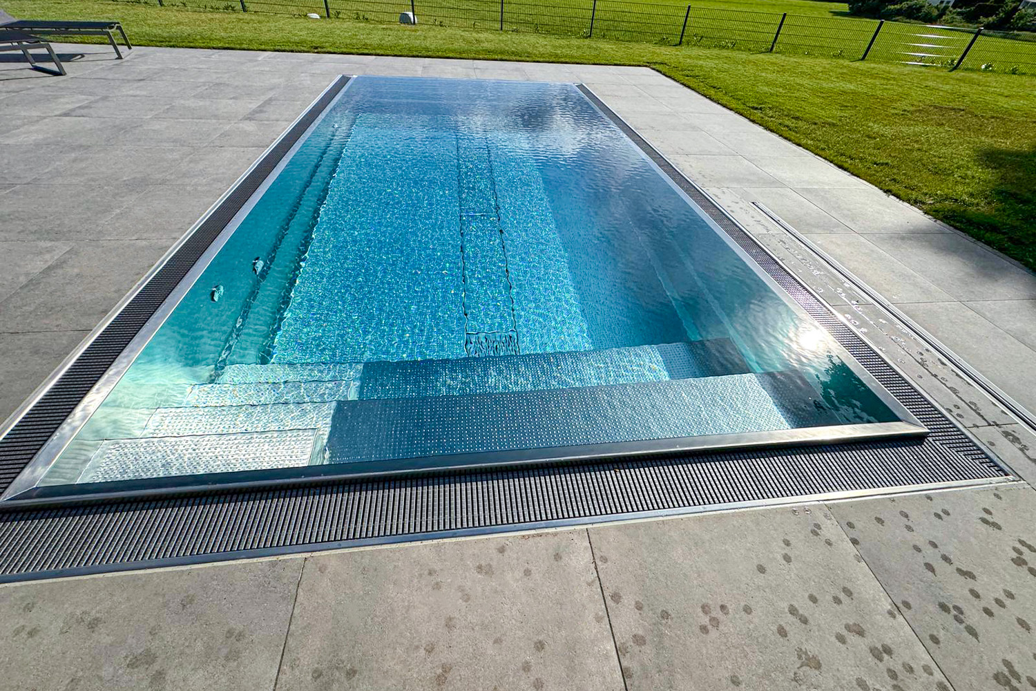 Edelstahlpool mit strukturierter Treppenanlage und Überlaufrand Detailaufnahme vom Treppenbereich im Edelstahl Überlaufpool mit strukturierter Oberfläche