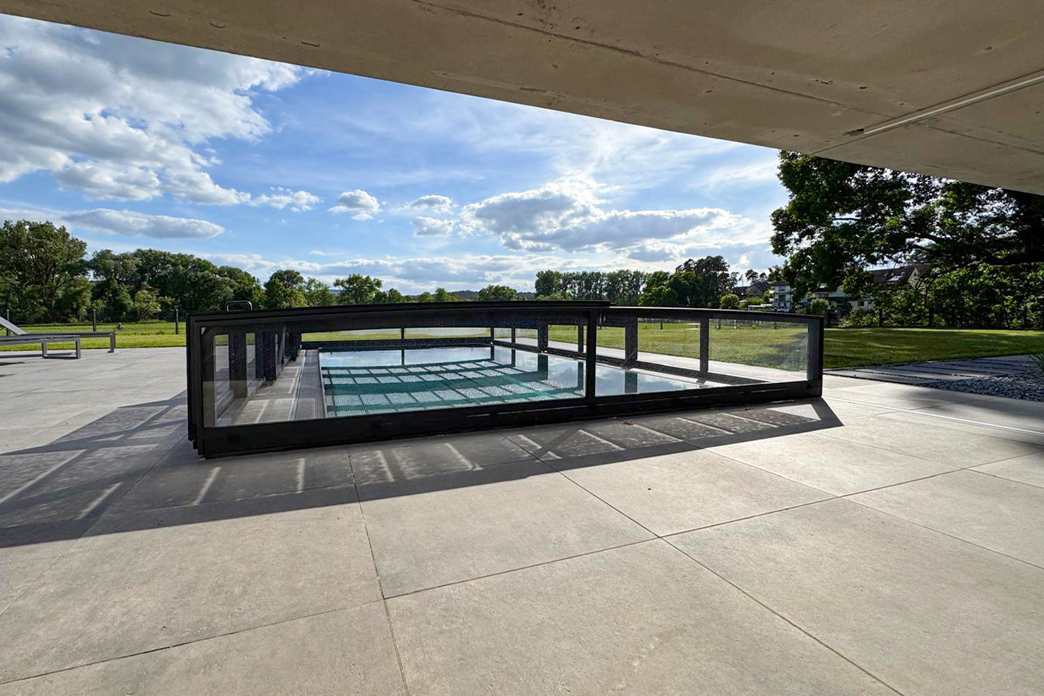 Aluna® NERO EASY R1 Poolüberdachung über Edelstahl-Schwimmbecken Superflache Poolüberdachung über einem Edelstahlpool mit klarer Linienführung